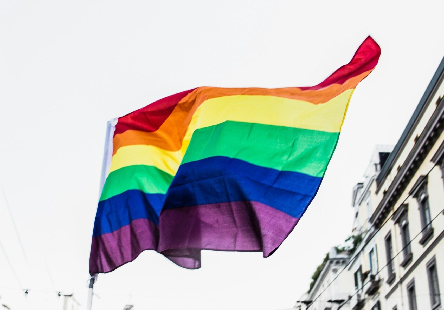 A rainbow flag flying over a street